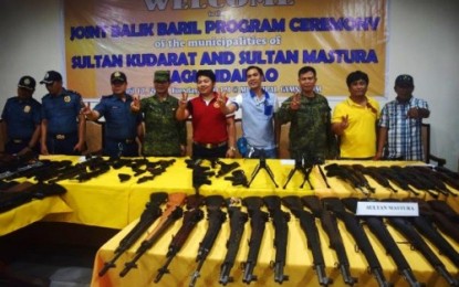 <p><strong>SURRENDERED.</strong> Mayors Datu Shameem Mastura (in red shirt) and Datu Rauf Mastura (in blue shirt) of Sultan Kudara and Sultan Mastura towns, respectively, flash the peace sign together with local military and police officials during the joint turnover ceremony of 76 loose firearms on Tuesday (April 17) at the municipal hall of Sultan Kudarat, Maguindanao. <em><strong>(Photo by 6ID)</strong></em></p>